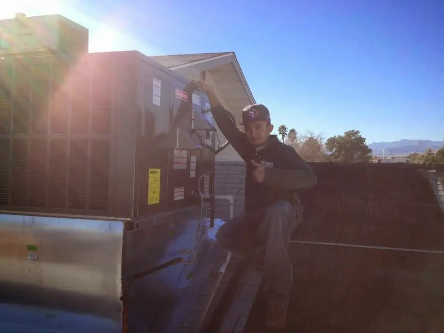 HVAC technician performing AC Tune-Up on a rooftop unit in Sebastopol
